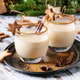 fancy eggnog surrounded by cookies